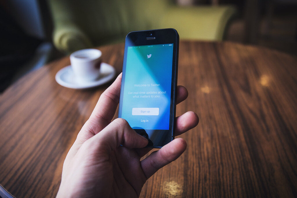 hand holding phone with social media app